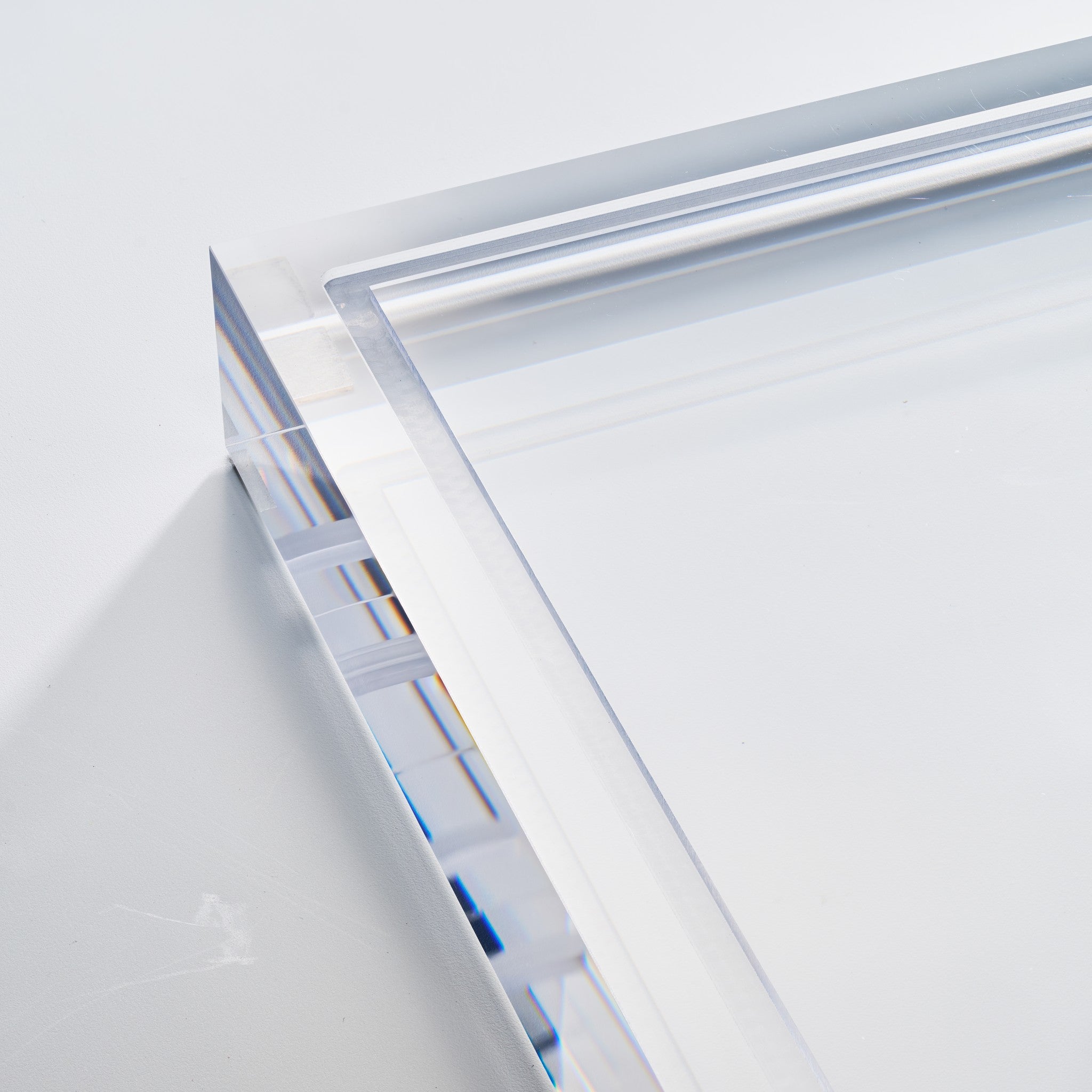 Macro detail of the polished corner edge on the solid acrylic base of the baseball display case