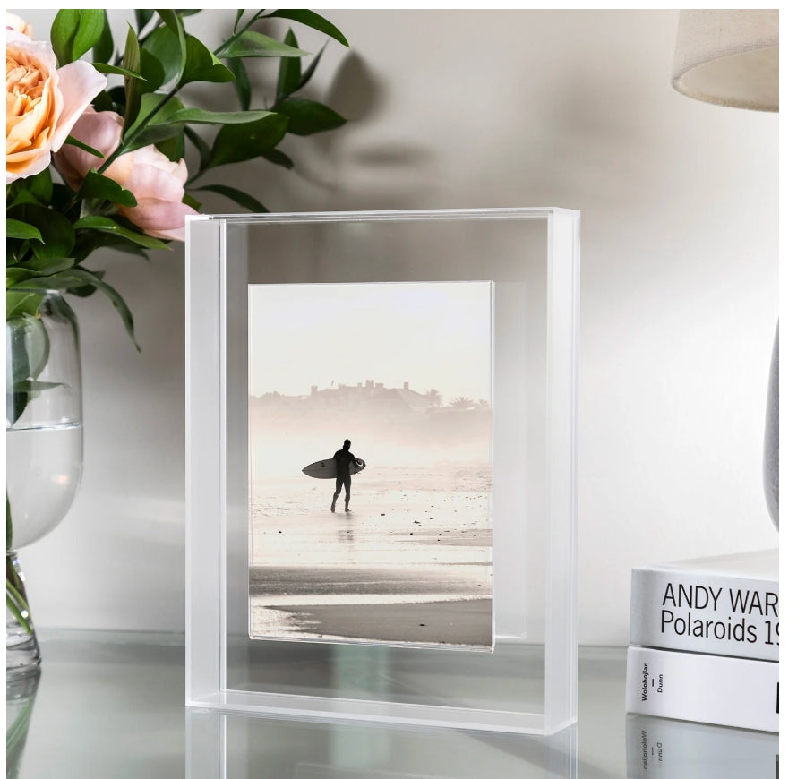 Magnetic Float Frame lifestyle hero - surfer photo with pink flowers and Andy Warhol Polaroids books